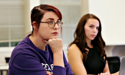 Two graduate students listen intently in an education class at Ӱɴý