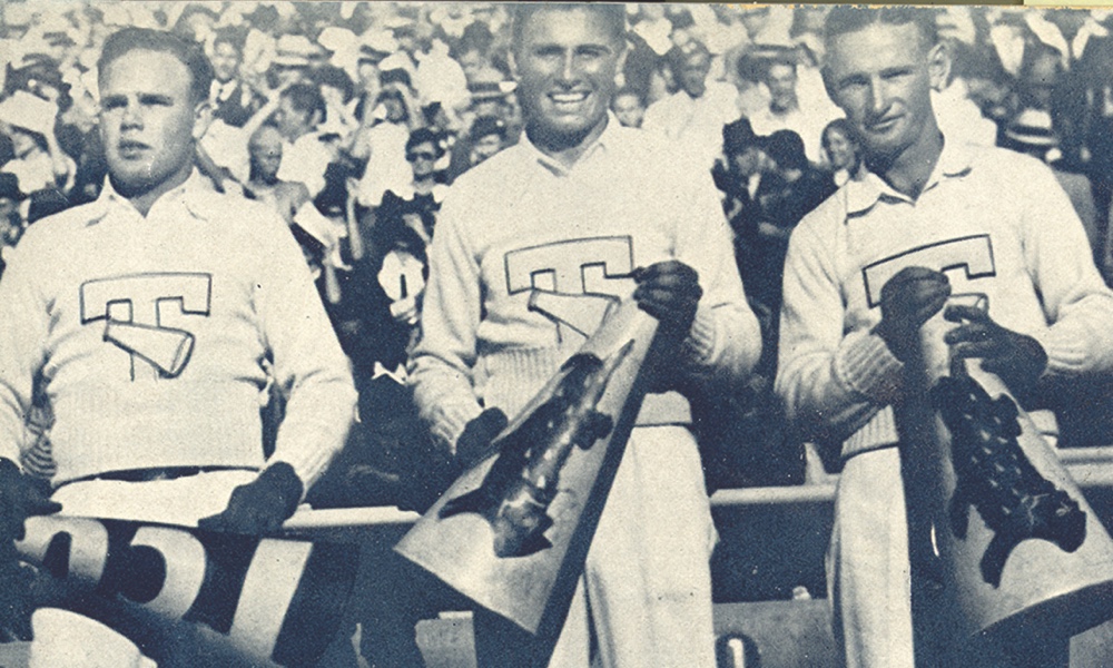 Three 1934 Ӱɴý male Yell Leaders smile holding megaphones