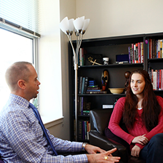 Rev. Todd Boling of Ӱɴý Religious and Spiritual Life talks to a student in his office.